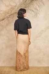 Pollera larga color rosa pálido, de tela satinada con encaje bordado en el ruedo.