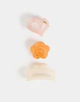 Set de tres broches para el pelo con forma de corazón rosa, flor naranja y broche rectangular blanco.
