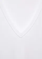 Remera blanca de corte recto, con cuello en V y mangas cortas.
