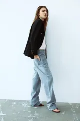 Blazer color blanco hueso, de corte entallado y doble botonadura dorada.