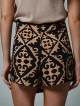 Falda short negra con estampado geométrico en color beige, con detalle de lazo lateral.