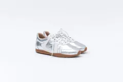 Zapatillas Magnolia plateadas con detalles en blanco y suela marrón.