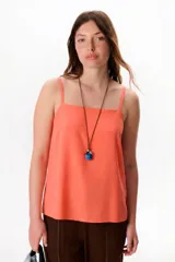 Musculosa color salmón de corte recto y breteles finos.