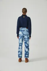 Pantalón de jean celeste con lavado batik, corte baggy, tiro alto y pierna ancha con botamanga ajustada.