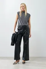 Blusa plateada de lurex con cuello alto y tablas en los hombros. Sin mangas.