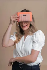 Billetera mediana de símil cuero color rosa, combinada con telar de colores amarillo, rosa y negro. Tiene compartimento interior con tarjeteros y cierre interior, monedero con cierre alrededor y correa de mano desmontable.