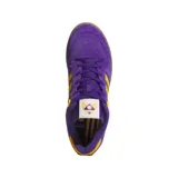 Championes Adidas Rivalry Low de gamuza color violeta con detalles en amarillo y suela marrón.