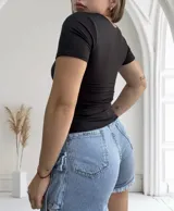 Remera negra ajustada al cuerpo, con escote cuadrado y mangas cortas.