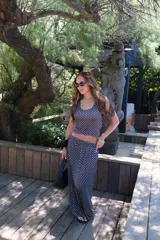 Pollera larga de viscosa, color azul marino con estampado de lunares blancos. Diseño de tiro alto y corte amplio.