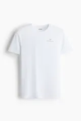 Remera deportiva blanca de manga corta y cuello redondo, con logo de la marca Zlatan en el pecho. Corte ajustado.