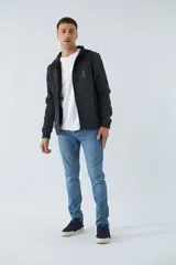 Campera negra con capucha ajustable, bolsillos con cierre y logo estampado.