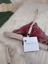 Conjunto de lencería de encaje color borgoña, compuesto por un bralette con breteles regulables y una tanga regulable de corte media less con entrepierna de algodón.
