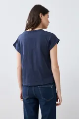 Remera color beige melange con escote en V y media cartera con botones.