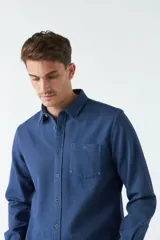 Camisa marrón de manga larga con bolsillo en el pecho y cierre con botones.