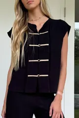 Blusa negra de lino tusor, sin mangas, con cuello mao y cierre frontal con presillas de soga.