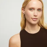 Pendientes largos con diseño de autor que combinan una base superior cóncava de metal bañado en plata, un cordón de cuero negro y un dije inferior en forma de corazón con terminación de esfera.