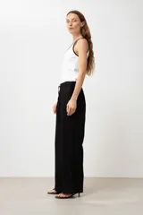 Pantalón de lino color marrón claro, de corte recto y tiro alto, con cintura elástica ajustable con cordón.