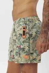 Short de baño con estampado de hojas de palmera en tonos beige, verde y naranja.