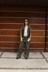 Chaleco marrón de cuero sintético con cuello solapa, cierre frontal asimétrico con cremallera, bolsillos con cremallera y corte ajustado.