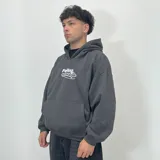 Buzo hoodie gris oscuro con capucha, corte boxy y bolsillo tipo canguro. Estampado frontal con el logo de la marca en color blanco.