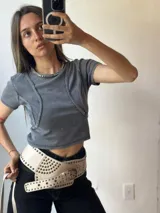 Remera gris de corte crop con cuello redondo y detalle de costuras a la vista.