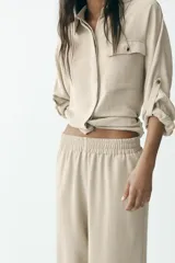 Pantalón marrón de tiro alto con cintura elástica y pierna ancha.