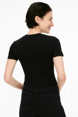 Remera blanca de algodón y elastano, de manga corta, corte ajustado y cuello alto.