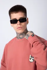 Buzo color crema de corte oversize confeccionado en tela friza con cuello redondo y puños y cintura acanalados. Presenta un pequeño bordado en el frente y un estampado grande en la espalda.