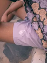 Short de baño lila con cintura elástica y logo bordado en blanco.