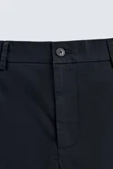 Pantalón chino color beige, de corte recto y tiro medio. Confeccionado en tejido de algodón con elasticidad, con bolsillos laterales y traseros de vivo. Cierre frontal con cremallera y botón.
