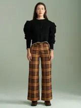 Cardigan negro de punto con cierre frontal de cremallera, cuello redondo y mangas abullonadas con detalle de pompones.