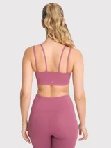 Top deportivo negro con tirantes dobles en la parte delantera y almohadillas removibles.