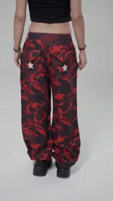 Pantalón de corte skinny, tiro bajo, con estampado camuflado en tonos rojo y negro, y estrellas blancas.