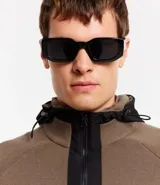 Cardigan de punto color marrón topo, con capucha negra contrastante y cierre frontal de cremallera negra. Presenta bolsillos laterales.