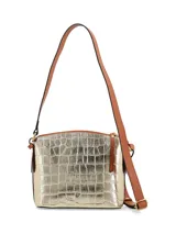 Cartera bandolera dorada con textura croco, correa de cuero marrón regulable y chapita metálica con logo de la marca.