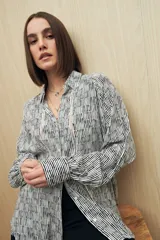 Camisa marrón con estampado animal print negro, de calce relajado, cuello clásico, abotonadura frontal y mangas largas con puños camiseros.