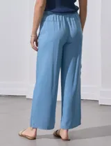 Pantalón de lyocell celeste, de corte ancho, con pretina elastizada con lazo de ajuste, bolsillos laterales y bolsillos cargo.