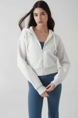 Campera deportiva color crudo, con cierre frontal y capucha, de ajuste cómodo.