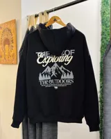 Canguro negro oversized con capucha y estampado en la espalda con montañas y texto en color gris.