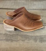 Zuecos color marrón claro con diseño bordado en el empeine, punta cuadrada y pequeño tacón.