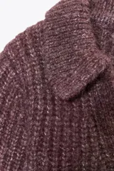 Jersey de punto color borgoña con cuello solapa y escote en pico. Tiene mangas cortas y bordados florales a tono.