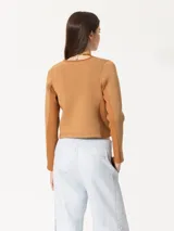 Hoodie marrón de tela de punto con recortes tejidos y lentejuelas en el delantero. Tiene terminación roll up en el escote y cierre frontal.