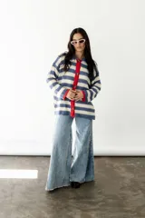 Camisa de algodón a rayas horizontales azules y blancas, con cuello camisero, cierre frontal con botones y mangas largas.