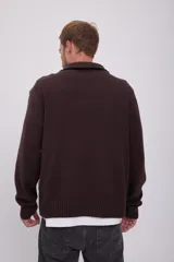 Sweater marrón de punto con cuello alto y cierre de cremallera metálica.