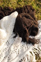 Bufanda triangular tejida en lana merino color marrón.