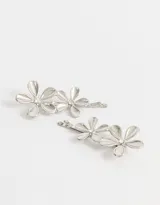 Set de dos horquillas doradas con apliques de flores y detalle de strass en el centro.