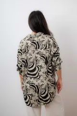 Camisa de mujer con estampado animal print en tonos beige y negro, de mangas largas con puños ajustados y corte moderno.