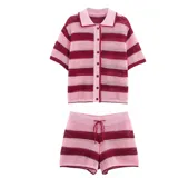 Conjunto tejido a crochet con rayas horizontales rosas y rojas. Incluye una camisa de mangas cortas con cuello polo y botones frontales, y un short con cordón ajustable en la cintura.
