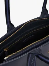 Bolso tote azul marino de poliuretano con cierre de cremallera, doble asa superior con inscripción de Tommy Hilfiger y logo TH dorado en el frente.