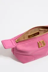 Monedero mini de nylon color fucsia, con forma trapezoidal, cierre de cremallera dorada y logo LB dorado en el frente.